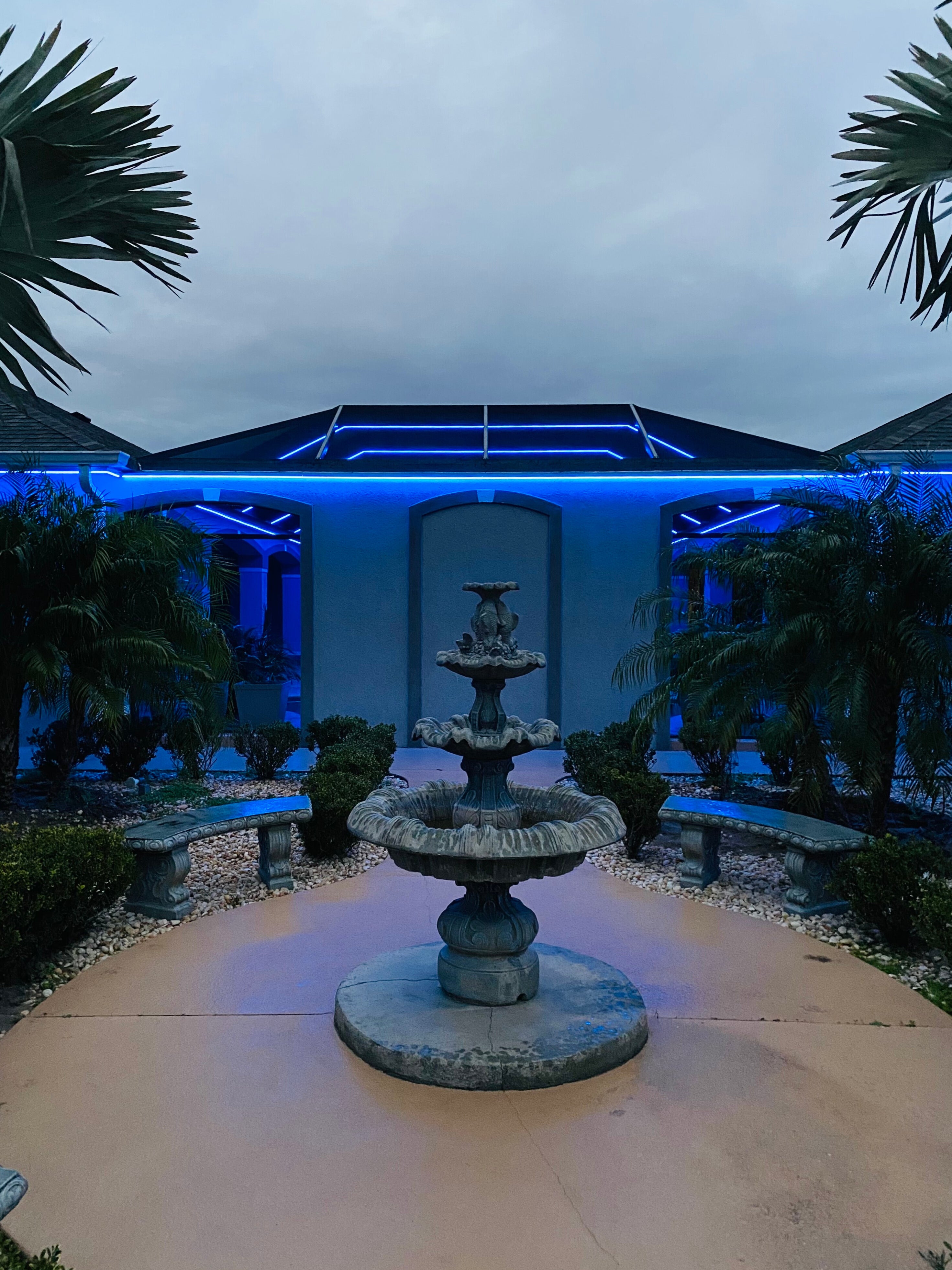 Blue permanent outdoor lighting installed on a pool cage and lanai area in The Villages, Florida