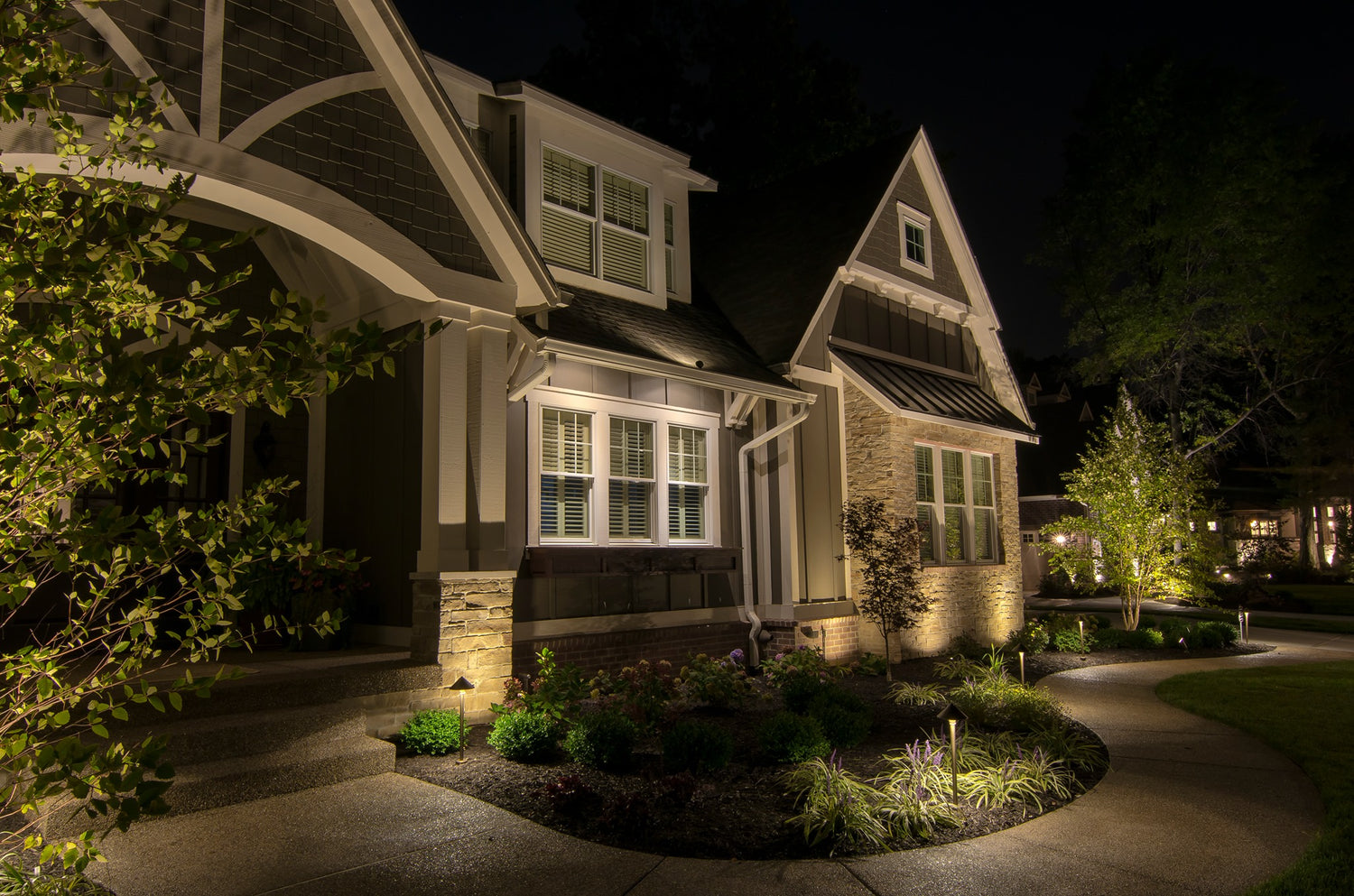 warm white landscape lighting illuminating home architecture and garden beds