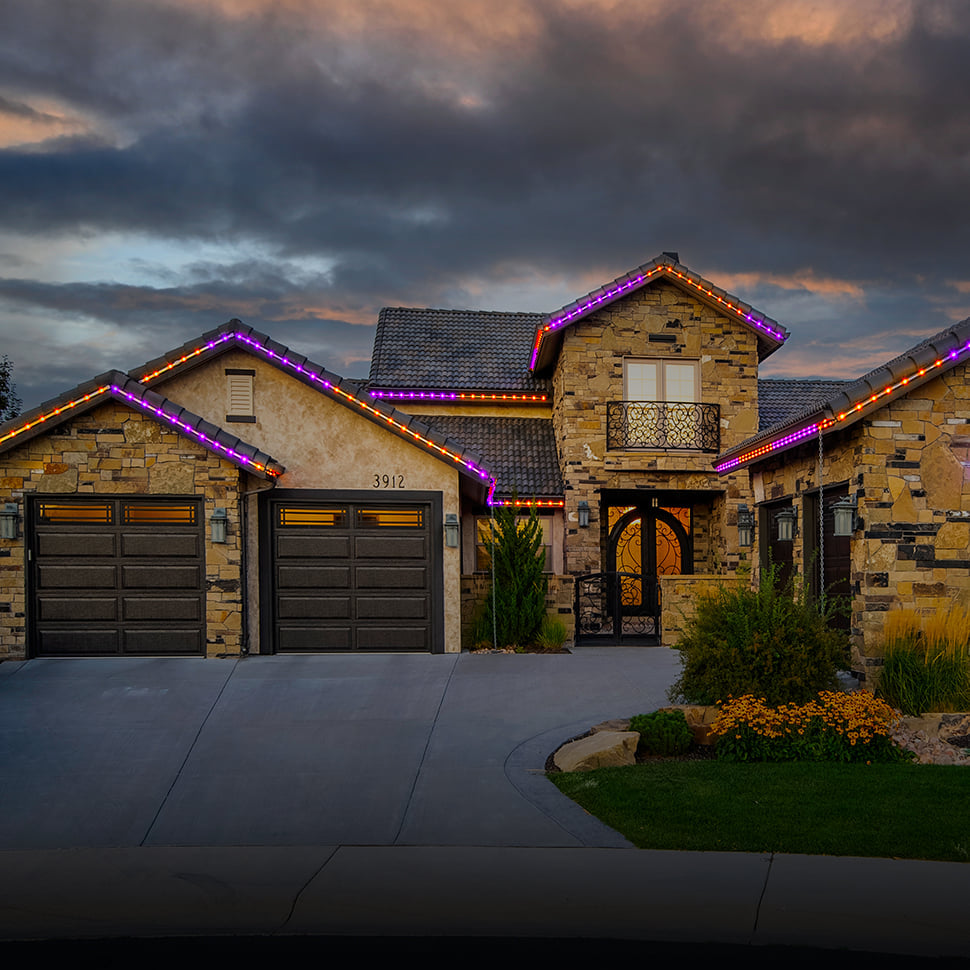 Color changing permanent roofline lighting displaying festive holiday colors on residential home