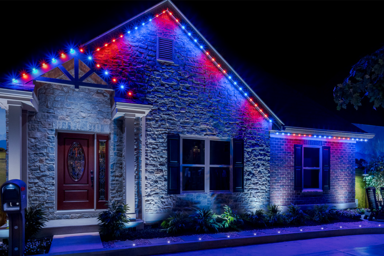Color changing permanent roofline lighting displaying red and blue LED lights on residential home