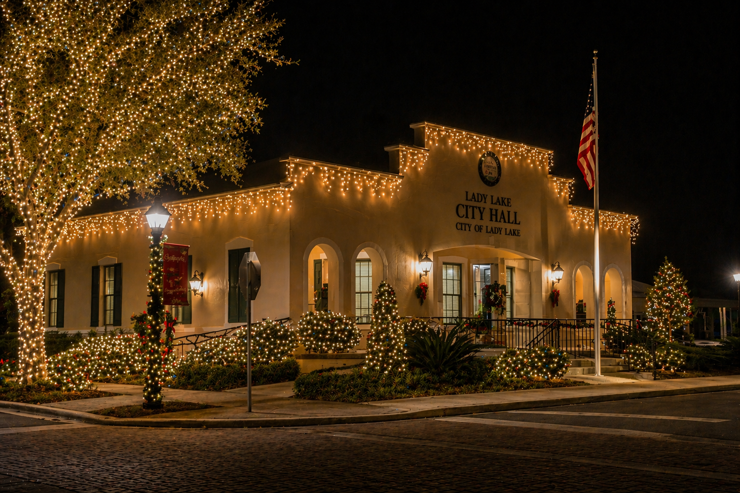 Custom temporary Christmas lighting installation on Lady Lake City Hall with roofline lights, tree wrapping, and holiday decorations in Lady Lake, FL
