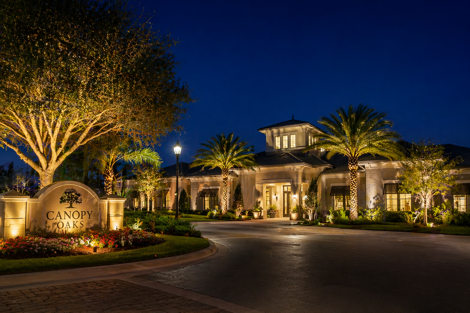Outdoor lighting illuminating an HOA clubhouse entrance with palm trees and landscape lighting in The Villages, FL
