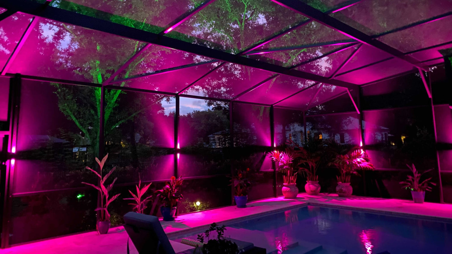 Outdoor lanai and pool cage lighting creating a vibrant backyard atmosphere
