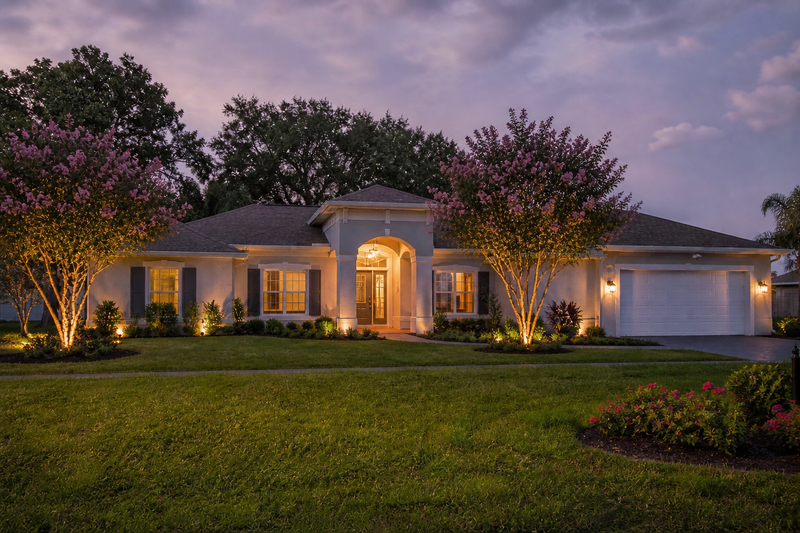 Custom outdoor lighting design in Umatilla Florida featuring front yard landscape lighting, tree uplighting, and warm architectural lighting on a residential home
