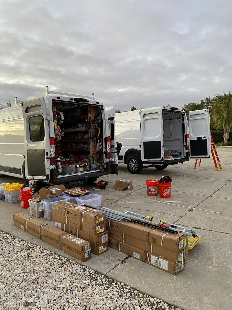 Light Glow work vans, tools, and materials prepared for an outdoor lighting installation in Florida