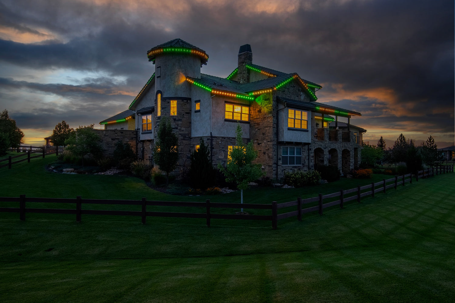 Permanent roofline lighting illuminating large residential estate home with color changing LED lights