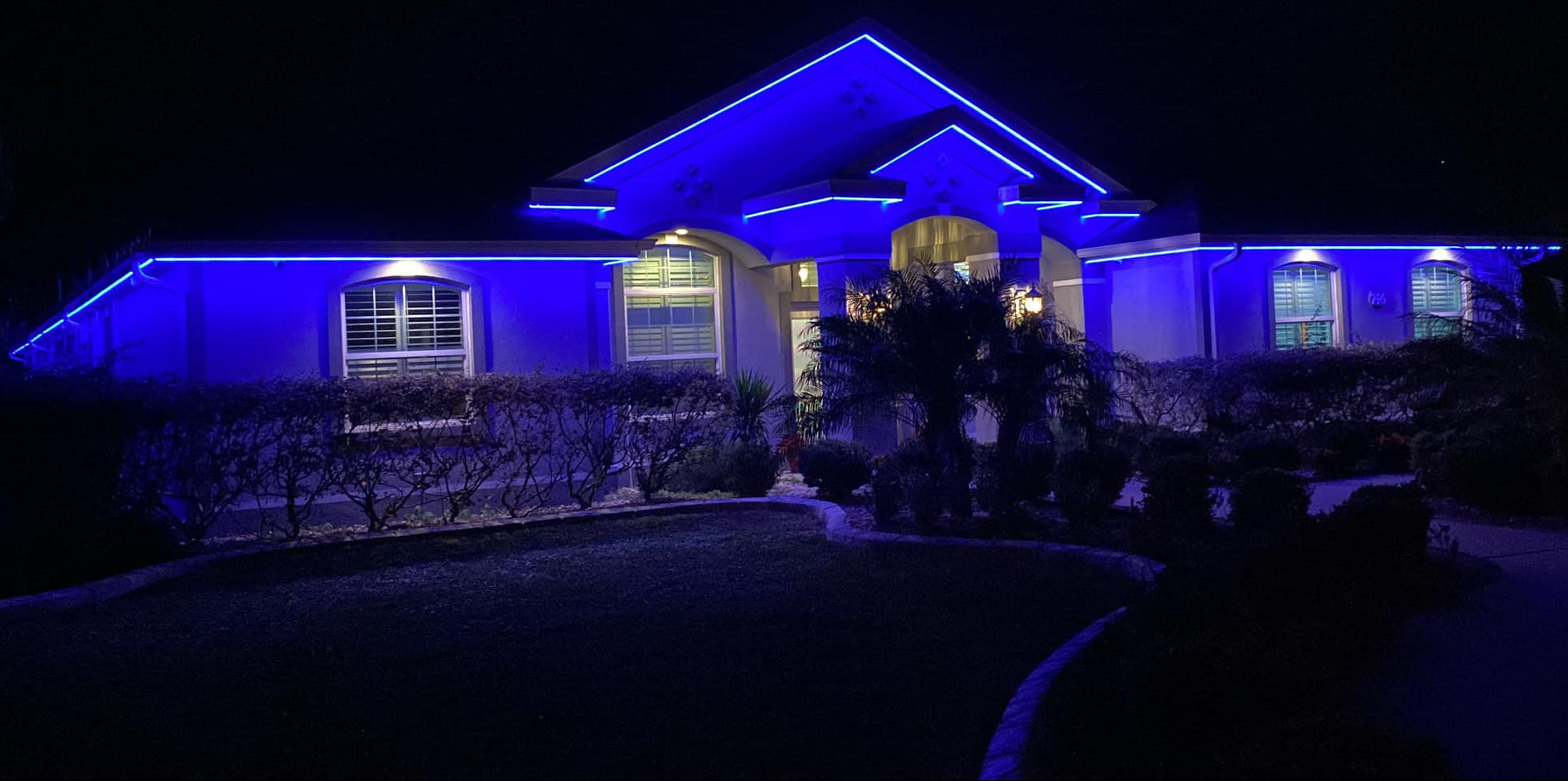 Permanent roofline lighting installation illuminating residential home exterior in The Villages Florida