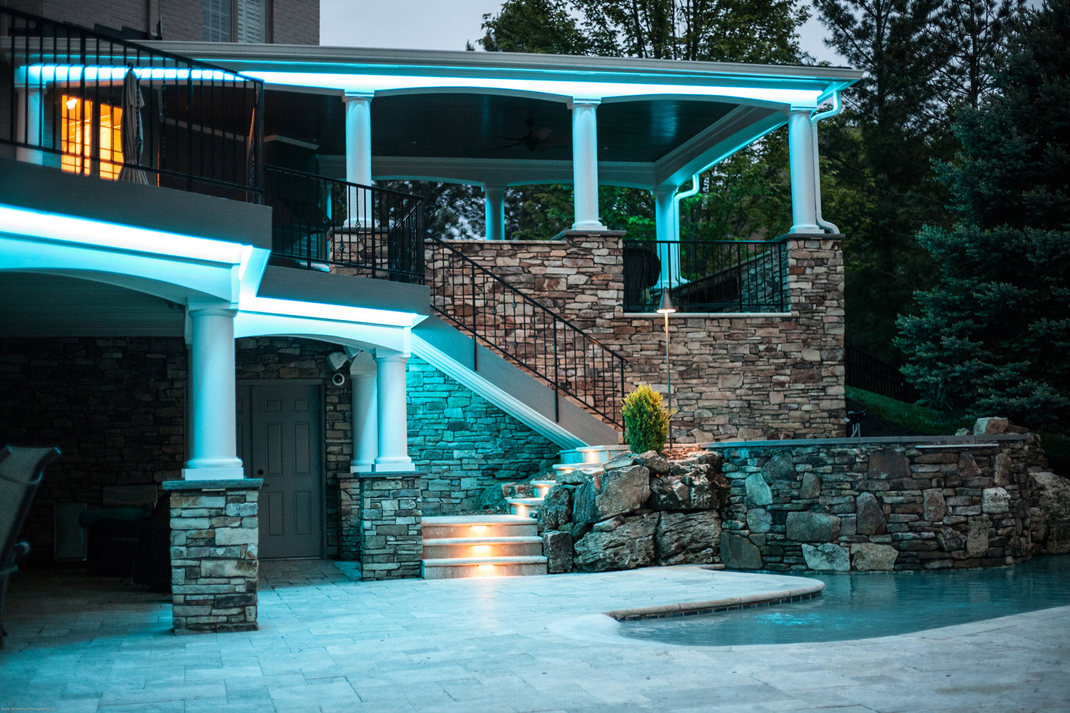 Architectural LED lighting installed on a pool house and outdoor patio structure highlighting columns and roofline details